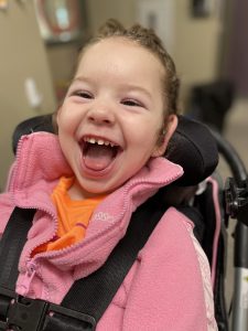 Little girl in a wheelchair with a big smile