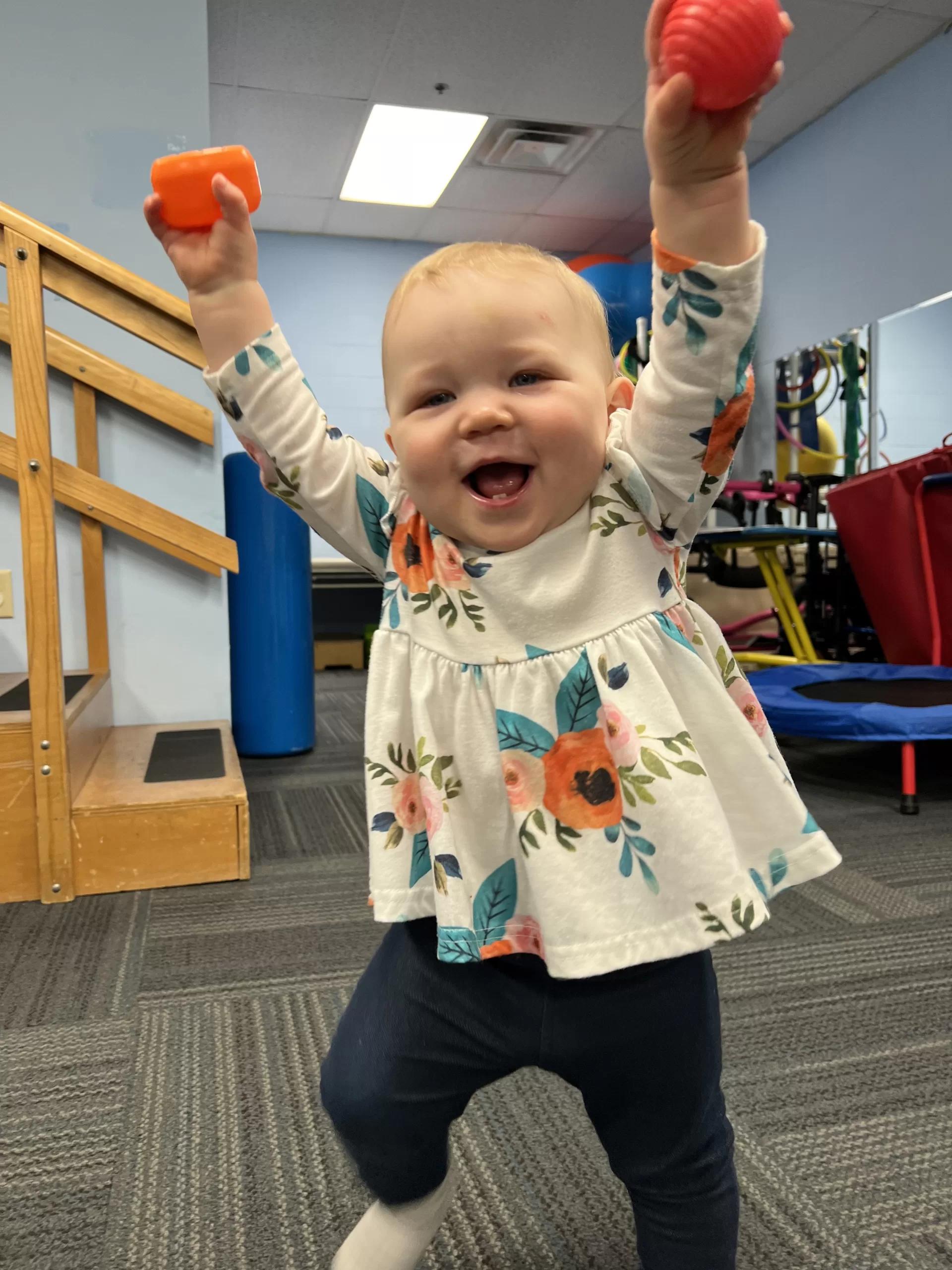 Luna celebrating with arms raised during physical therapy