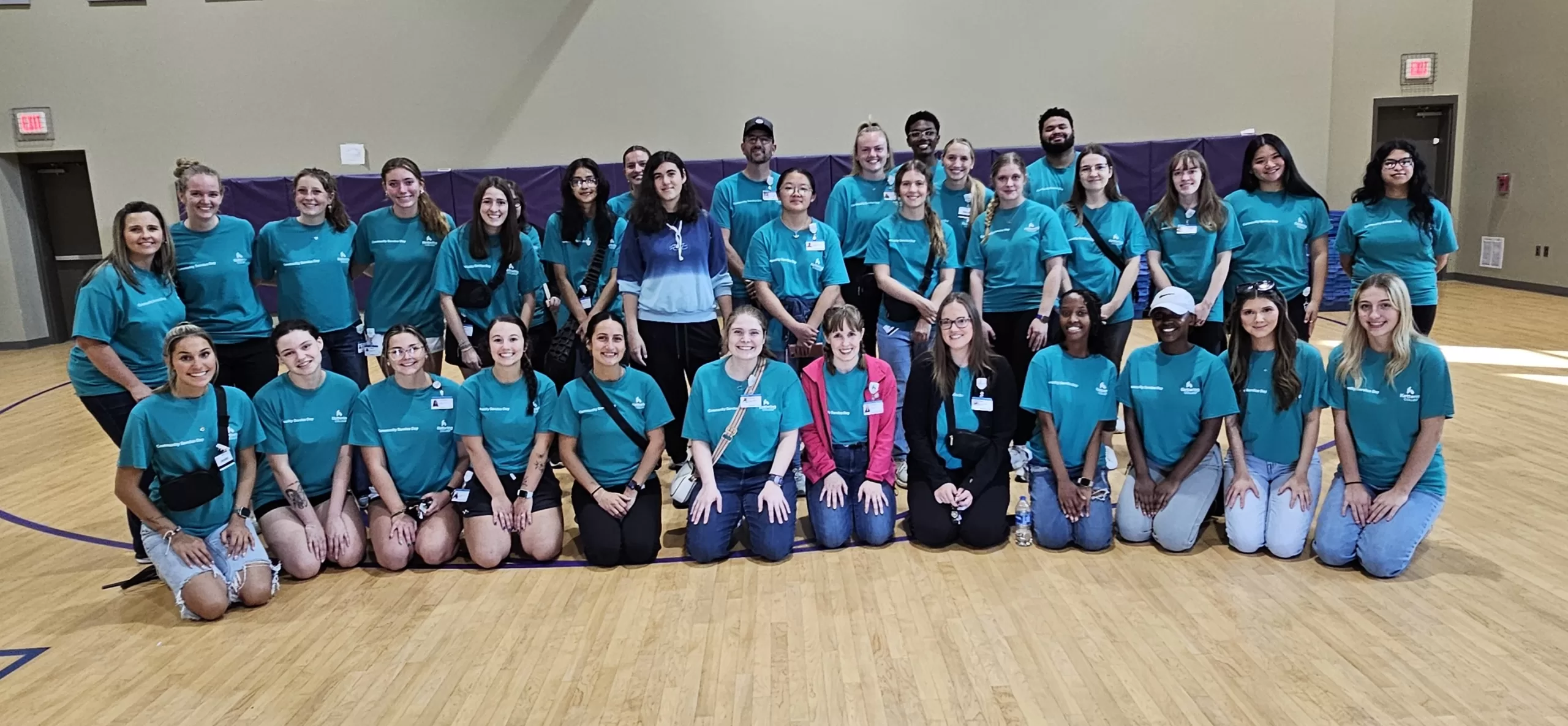 Large group of URS volunteers in teal shirts